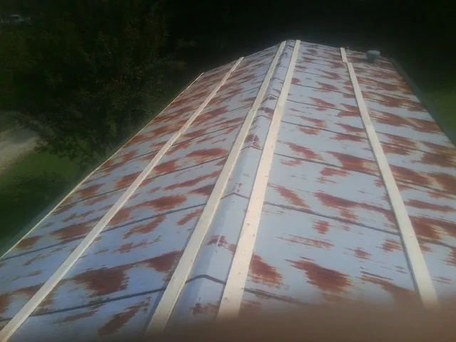 Rusted metal roof panels with new wood purlins before replacement — Storm Damage Roof Repair in Mocksville by Roofing Brothers