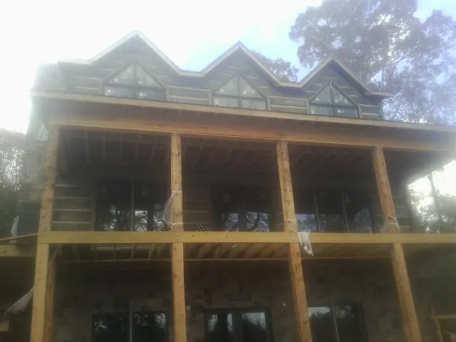 Dormers and porch framing on a large log home under construction — Roof Coating work by our crew in Mocksville