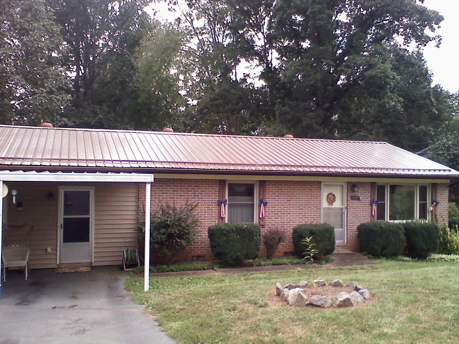 Bronze metal roof and carport on a brick ranch home — Roof Repair work by our crew in Mocksville