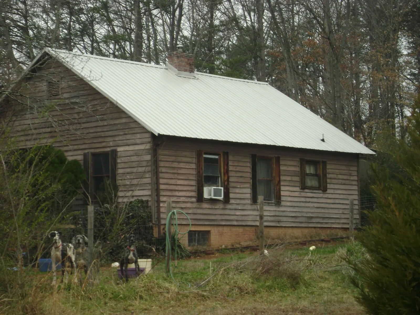 White metal roof on an old wood sided farmhouse, from a Metal Roof Installation job in Mocksville